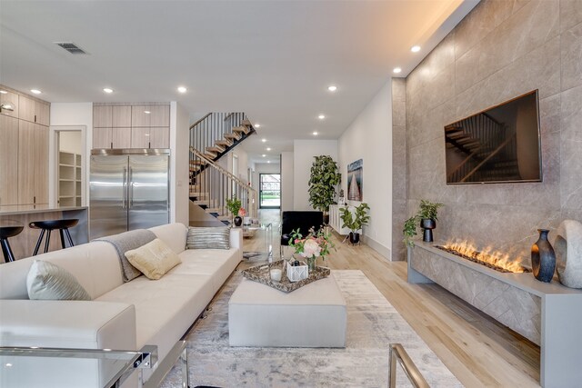 living room with light wood-type flooring and a fireplace