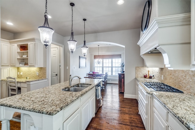 kitchen featuring dark hardwood / wood-style floors, sink, pendant lighting, and an island with sink