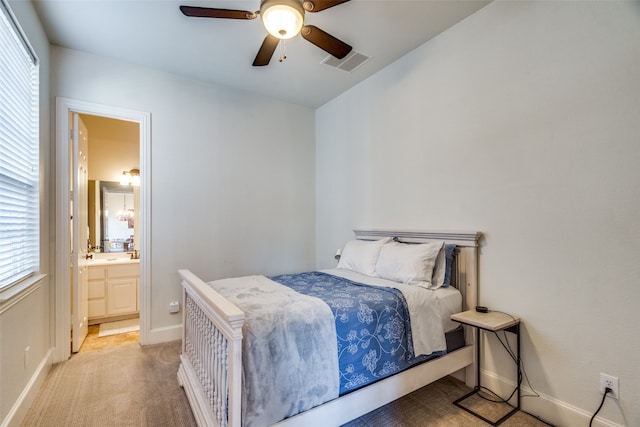 carpeted bedroom with multiple windows, ensuite bathroom, and ceiling fan