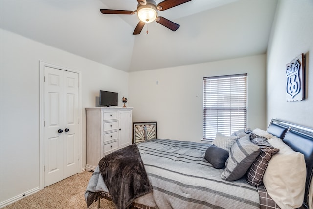 carpeted bedroom with vaulted ceiling, a closet, and ceiling fan