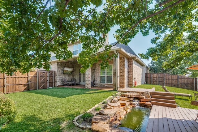 rear view of house featuring a patio area, a deck, and a lawn