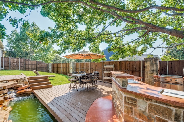 wooden deck featuring a yard and a grill