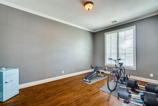 workout area featuring hardwood / wood-style flooring and ornamental molding