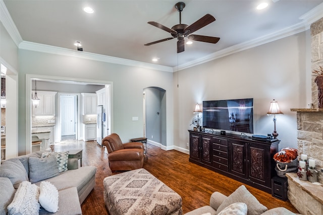 living room with ornamental molding, ceiling fan, a fireplace, and dark hardwood / wood-style flooring