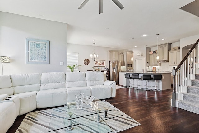 living room featuring sink, dark wood-type flooring, and ceiling fan with notable chandelier