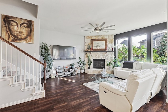 living room with a fireplace, dark wood-type flooring, and ceiling fan