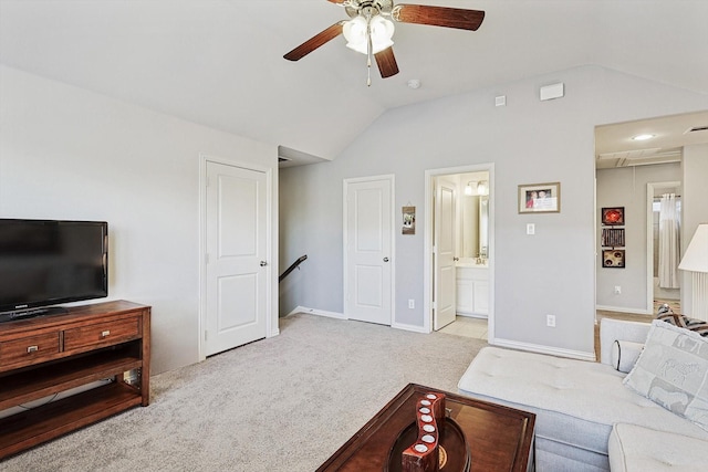 carpeted living room with ceiling fan and vaulted ceiling