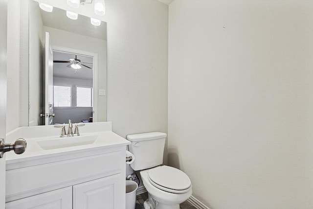 bathroom with toilet, vanity, and ceiling fan