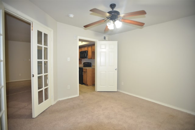 carpeted empty room featuring french doors and ceiling fan