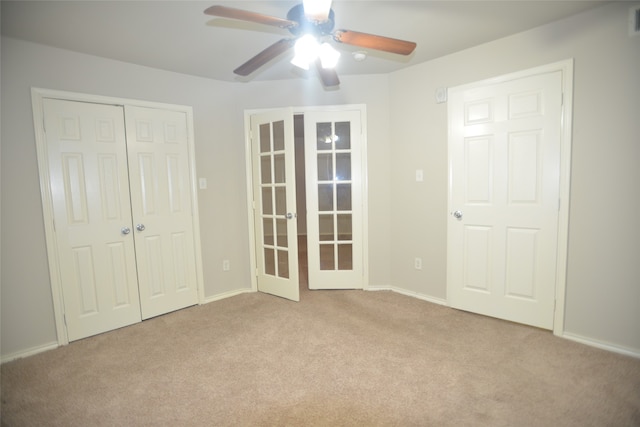 unfurnished bedroom with french doors, ceiling fan, light carpet, and a closet