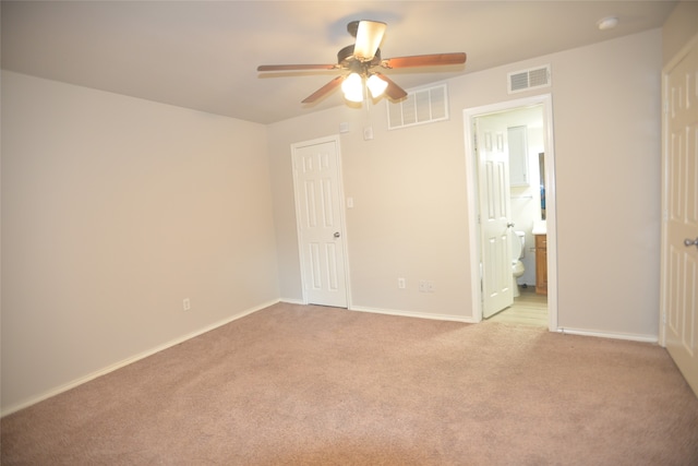 unfurnished bedroom with light colored carpet, connected bathroom, and ceiling fan