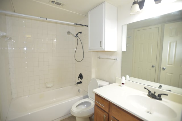 full bathroom with tiled shower / bath, vanity, and toilet