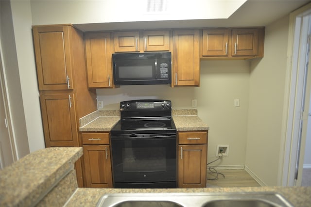 kitchen featuring light hardwood / wood-style flooring and black appliances