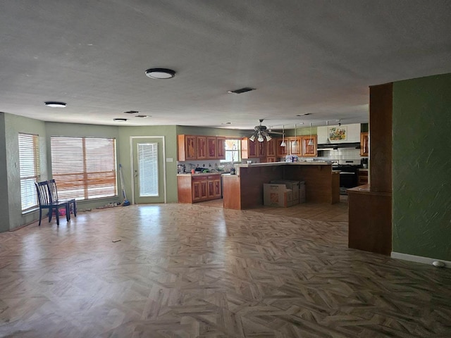 kitchen featuring a kitchen bar, a kitchen island, backsplash, hanging light fixtures, and ceiling fan