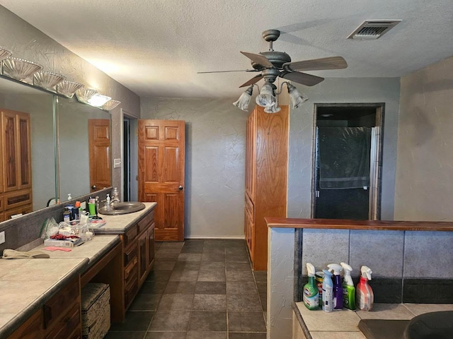 bathroom featuring vanity, a textured ceiling, and ceiling fan