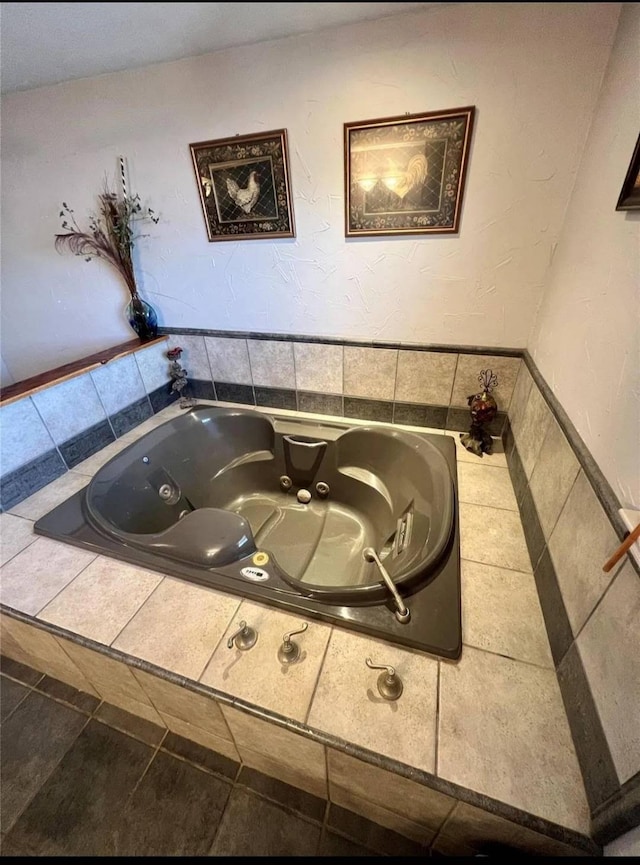 bathroom with a relaxing tiled tub and tile patterned flooring