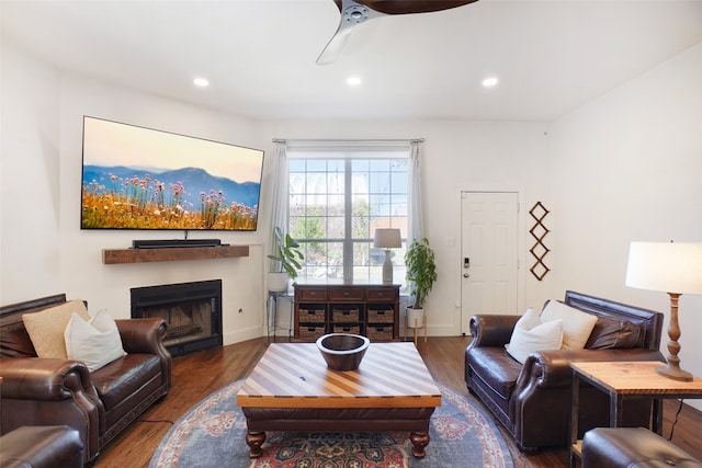 living room featuring ceiling fan and dark wood-type flooring