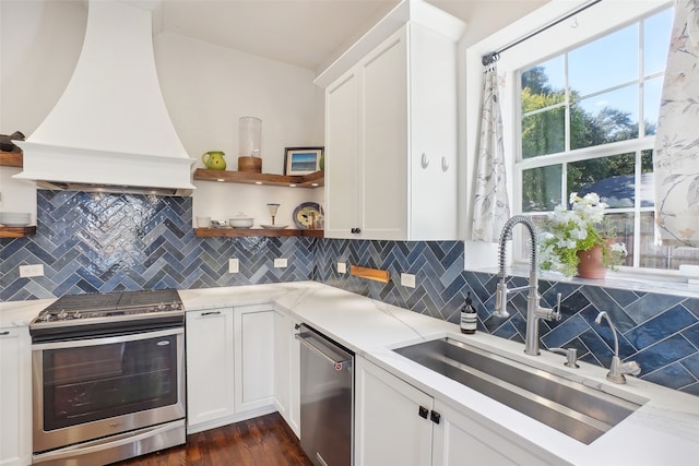 kitchen with white cabinetry, sink, dark wood-type flooring, stainless steel appliances, and premium range hood