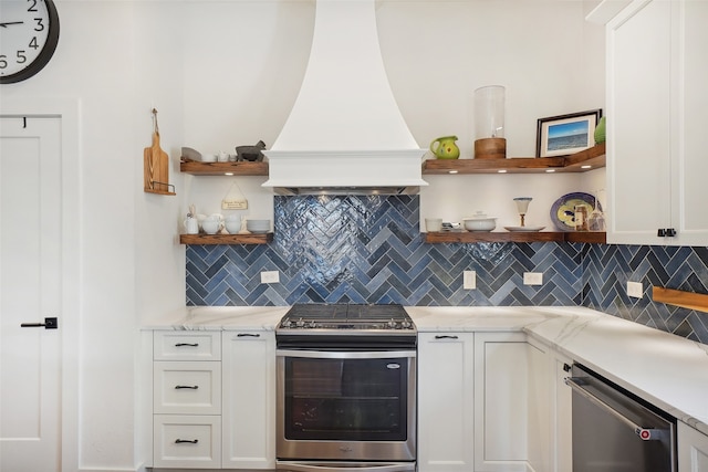 kitchen with white cabinets, appliances with stainless steel finishes, tasteful backsplash, and custom range hood