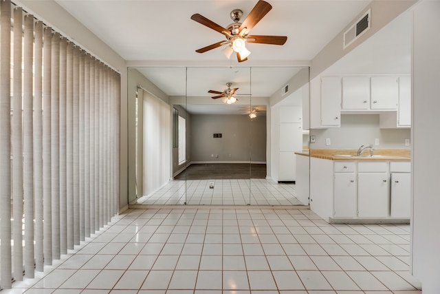 kitchen featuring white cabinetry, sink, and ceiling fan