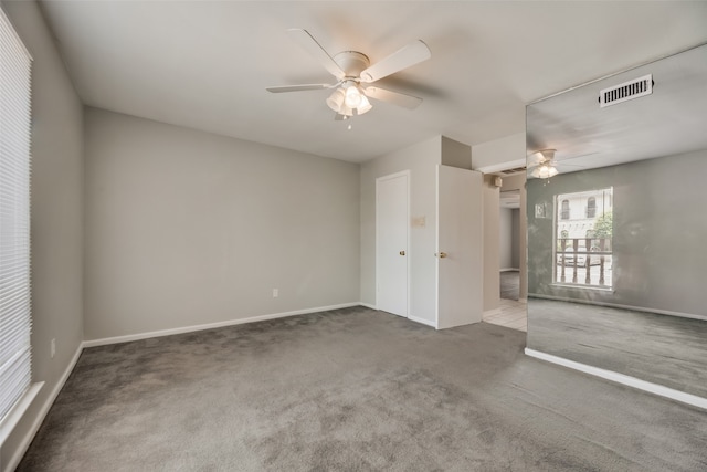 spare room with dark carpet and ceiling fan