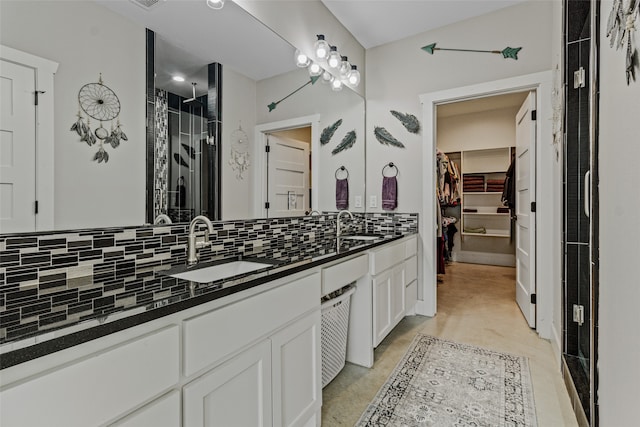 bathroom with vanity, decorative backsplash, and a shower with shower door