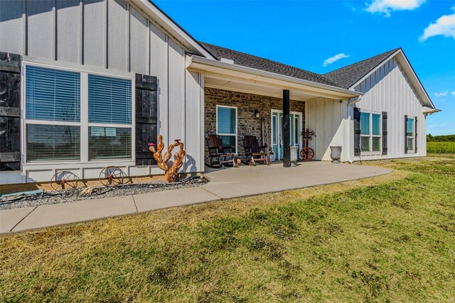 rear view of house featuring a patio and a lawn