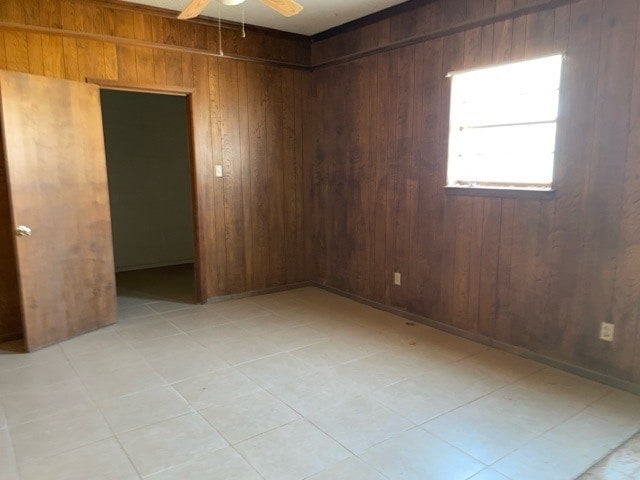 unfurnished room with wooden walls and ceiling fan