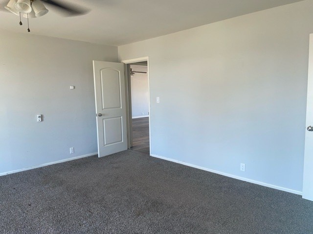 carpeted empty room featuring ceiling fan