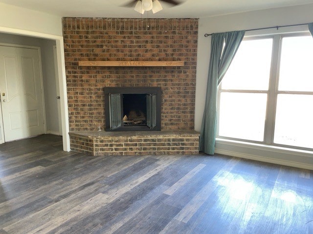 unfurnished living room with a wealth of natural light, ceiling fan, and dark hardwood / wood-style flooring