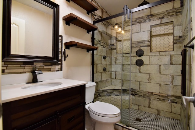 bathroom with vanity, tasteful backsplash, toilet, and a shower with shower door