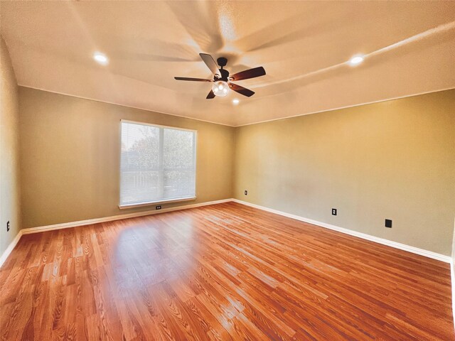 empty room with ceiling fan and hardwood / wood-style flooring