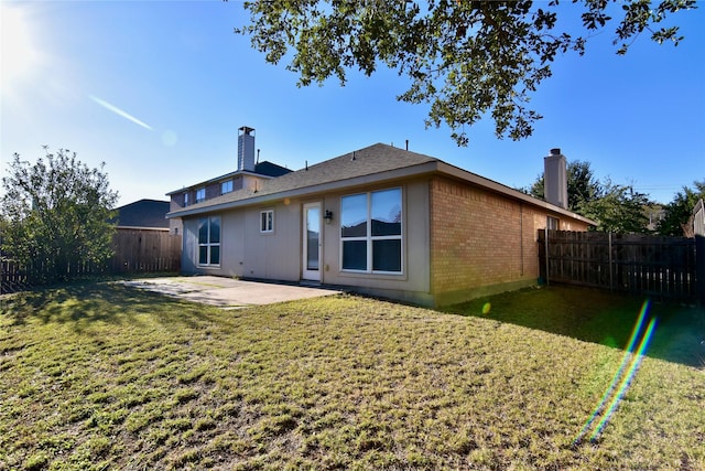 rear view of house featuring a lawn and a patio