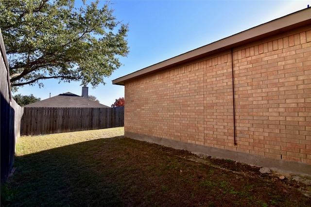 view of side of home with a yard