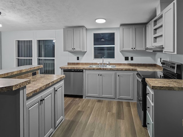 kitchen with gray cabinets, sink, stainless steel appliances, and dark hardwood / wood-style floors