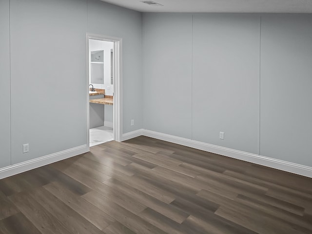 unfurnished room with dark wood-type flooring