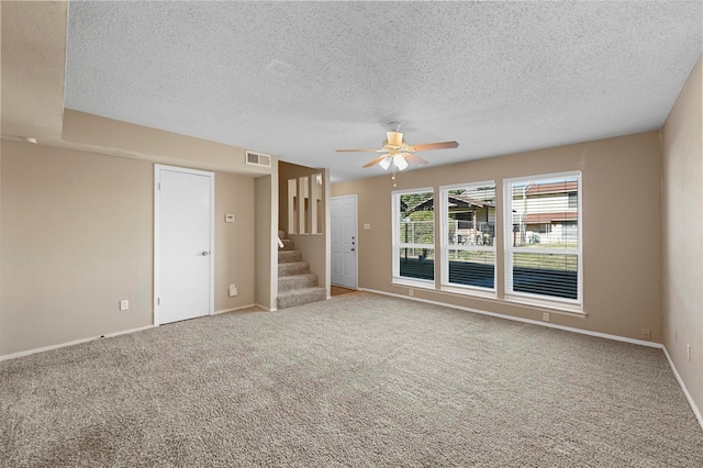 spare room featuring a textured ceiling, carpet, and ceiling fan