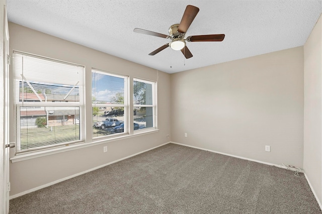 spare room with a textured ceiling, carpet floors, and ceiling fan