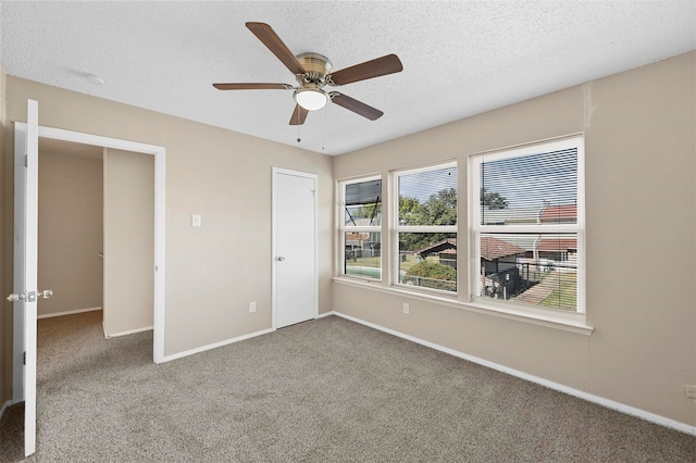 unfurnished bedroom featuring carpet floors, a textured ceiling, and ceiling fan