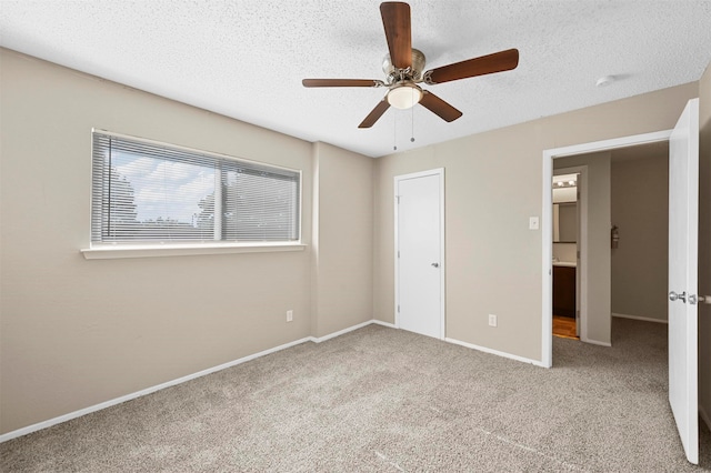 unfurnished bedroom with ceiling fan, light carpet, and a textured ceiling