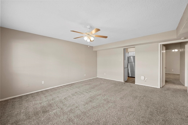 empty room with ceiling fan, carpet flooring, and a textured ceiling