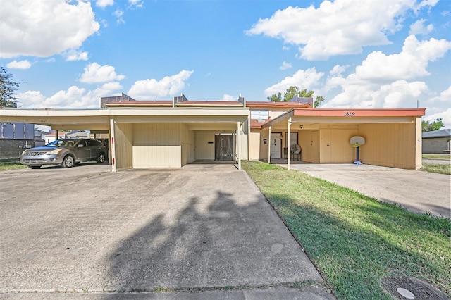 single story home featuring a carport and a front lawn