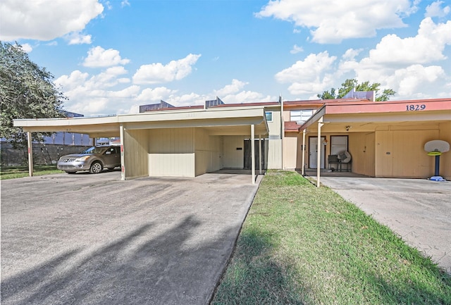 view of front of property featuring a front yard and a carport