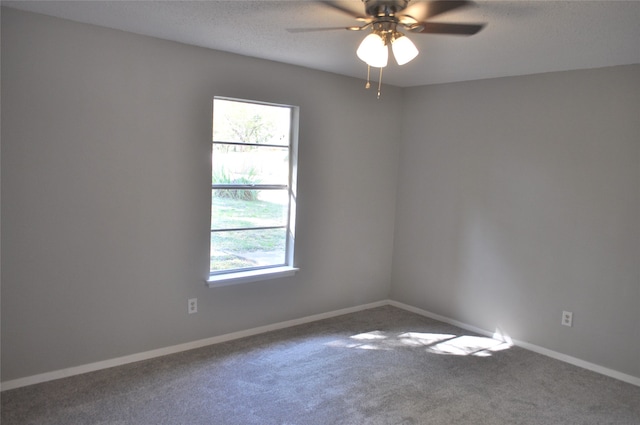 carpeted empty room with ceiling fan, a healthy amount of sunlight, and a textured ceiling