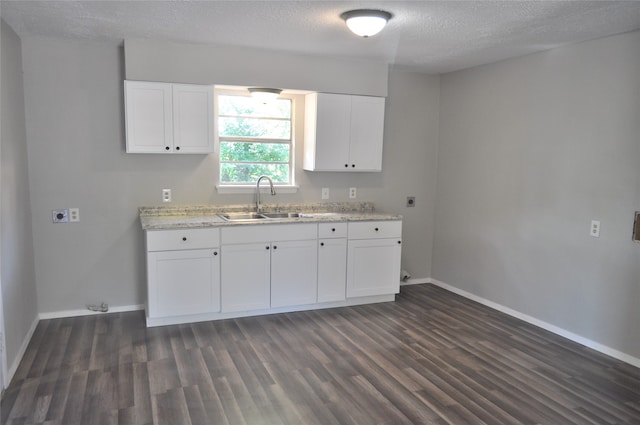 kitchen with sink, white cabinets, and dark wood-type flooring