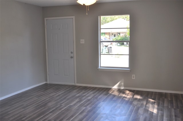 empty room with ceiling fan and dark hardwood / wood-style flooring