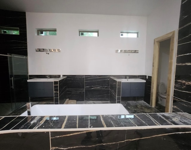 full bathroom with vanity, toilet, independent shower and bath, and tile walls