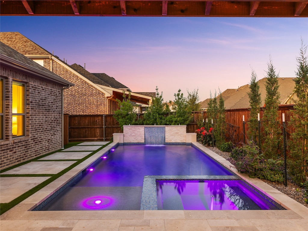 pool at dusk with a patio