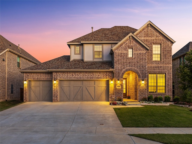 view of front of property with a yard and a garage