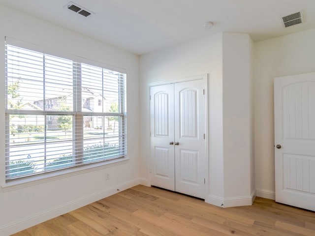 unfurnished bedroom with light hardwood / wood-style floors and a closet